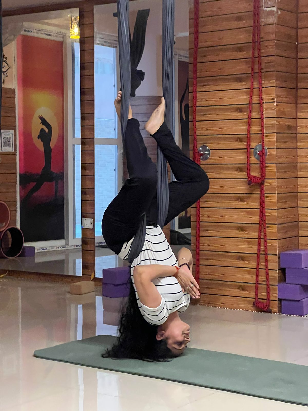 Student in an inverted aerial backbend draped in a yoga hammock