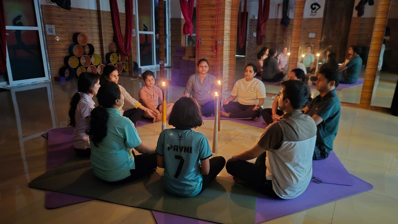 Group seated in a warm candlelit meditation circle