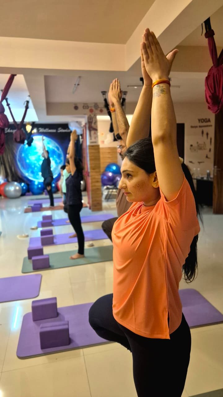 Student in Tree Pose with the group practising behind